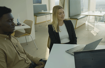 Two graduates sitting at a table applying