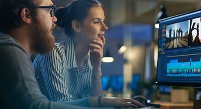 Two people sat together, observing something on a computer screen